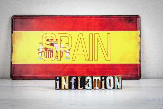 Image symbolizing inflation in Spain with the Spanish flag in the background and the word inflation displayed in colorful vintage wooden block letters