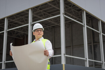 Male engineer. drawing. drawing and engineer. construction site. High quality photo.