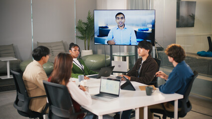 Diverse group in modern office collaborates on startup project teamwork with video conference leader sharing ideas for success and innovation in creative workspace