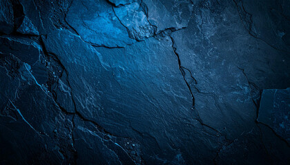 Naklejka premium Dark blue slate stone texture with deep fissures and uneven surface. The image showcases a close-up view of a rough, naturally fractured rock.