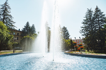 city fountain in the center of Stavropol with a rainbow on the water jets. Sunny day, freshness and...