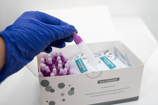 Doctor wearing blue nitrile gloves taking buffer solution from rapid test kit