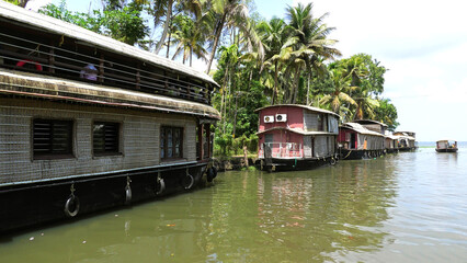 Obraz premium Large houseboats moored on the side of a canal in Kerala, India