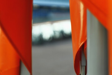 Close-up abstract image of bright orange fabric with folds and blurred background. Minimalist design detail with strong color contrast.