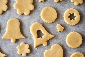 Shapes made of rolled out pastry dough on baking paper - preparation of Linzer Christmas cookies