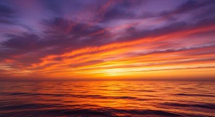 Obraz premium Stunning vibrant sunset paints the ocean with fiery orange and purple hues, a breathtaking natural spectacle.
