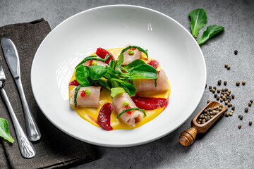 Delicate rolls on a modern dining plate. Vibrant food presentation features rolled ingredients topped with fresh greens for a delightful culinary experience.