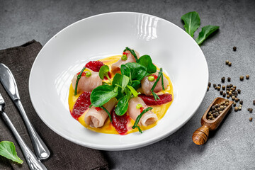 Citrus-garnished meat rolls. Artfully arranged meat rolls topped with citrus slices and fresh greens on a modern kitchen table.