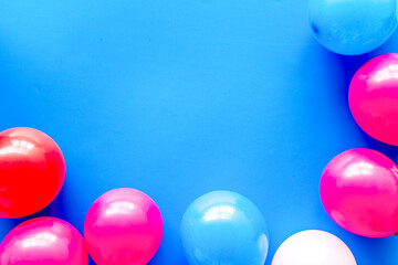 Decorative frame with colorful balloons on blue background top-down frame copy space