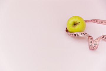 measuring tape and green apple On Light Pink Background, Space For Text, Space For Logo, Healthy Lifestyle