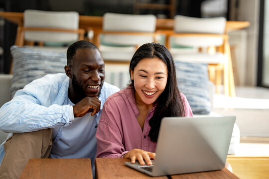 Online entertainment and social media. Diverse, multiethnic couple enjoying the digital world