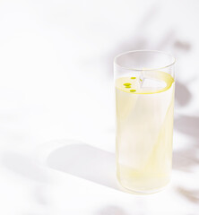 Refreshing lemon beverage sits elegantly in a clear glass on a bright surface