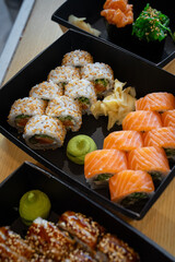 Sushi set with wasabi and ginger in takeaway box.