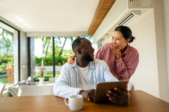 Online entertainment and social media. Diverse, multiethnic couple enjoying the digital world - Powered by Adobe