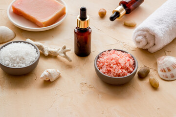 Spa treatment body care cosmetics close up. Sea salt in bowl and essential oil on bottle