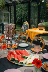 Elegant summer table setting with colorful canap&eacute;s and seasonal fruits.