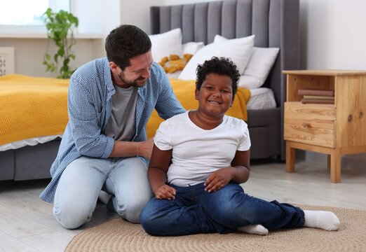 Adoption. Father and his son on floor at home