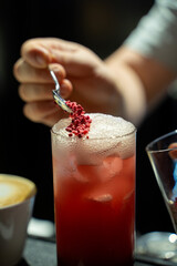 Raspberry Cocktail Served by Bartender’s Hand and decor.