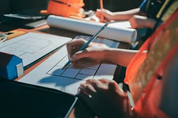 Closeup of team of industrial engineers meeting analyze machinery blueprints consult project on table in manufacturing factory. Working in manufacturing plant or production plant.