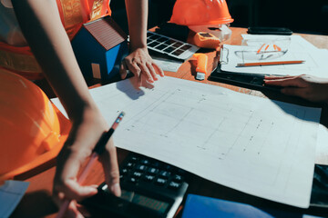 Closeup of team of industrial engineers meeting analyze machinery blueprints consult project on table in manufacturing factory. Working in manufacturing plant or production plant.