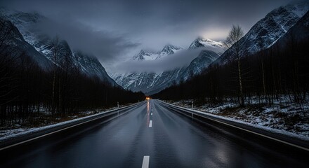Wet Road Through Snowy Mountains at Twilight