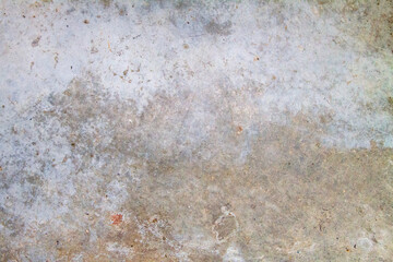 Close-up of a weathered concrete surface with mottled textures and subtle color variations.