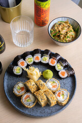 Variety of sushi and wakame seaweed salad flat lay.