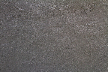 Textured gray wall surface with subtle variations and shadows.