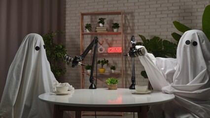 Two funny ghosts record a podcast in a studio
