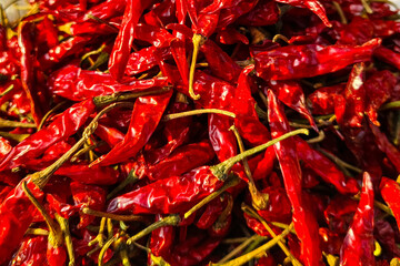 A variety of spices, including red chili peppers, are displayed at a market in Asia.