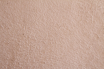 Close-up of a textured, pinkish-beige wall surface