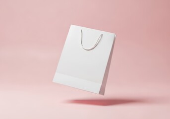Blank white shopping bag levitating on pink background featuring simple design and silver handles