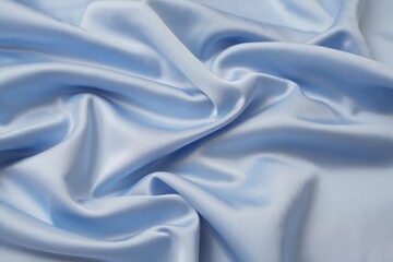 Obraz premium Soft flowing light blue satin fabric with elegant folds and highlights