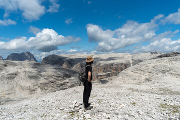 Traveler standing on rocky mountain summit looking at horizon