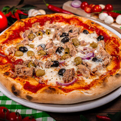 Pizza with tuna and red onion wooden background