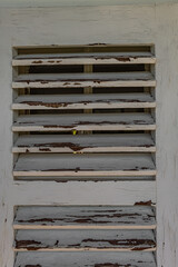 Old wooden shutters on the apartment windows, peeling paint from the windows