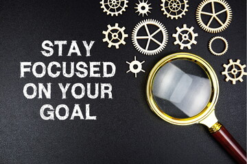 Stay Focused On Your Goals text message with magnifying glass on black background