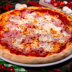 Pizza with prosciutto parma ham on wooden background top view. Italian cuisine