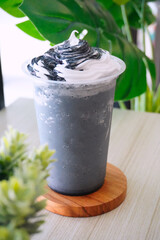 Fresh creamy milkshake served on cafe table with natural light, modern interior background, refreshing beverage concept for lifestyle dining