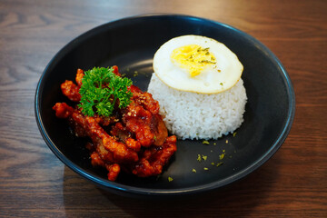 Delicious Fried Chicken with Rice and Fried Egg Served on Black Plate – Asian Cuisine Food Photography