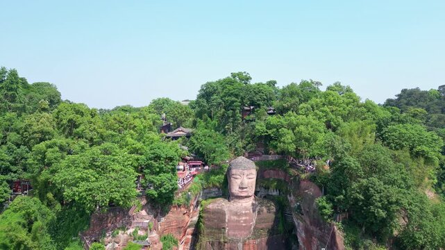 Leshan, China: Aerial drone footage of the famous Leshan giant Buddha stone statue  at the confluence of the Min River and Dadu River in Sichuan in China. Shot with a downward motion