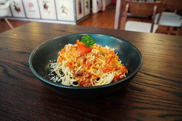 Delicious Stir-Fried Noodles with Vegetables in Black Bowl on Wooden Table