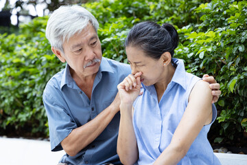 Obraz premium Asian couple of senior husband and wife, man taking care of sick allergic woman with runny nose, concept for couple family, care and togetherness, health care, couple family wellness