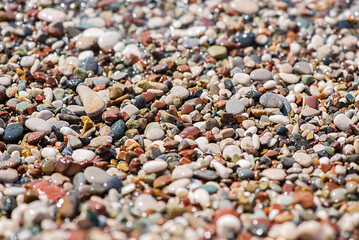 Sea colored pebbles on the beach, clear sea water