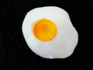 fried egg on black background