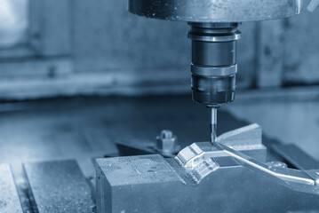 The CNC milling machine finish cut the stamping die parts by solid ball nose end mill tool in the light blue scene.