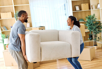 Portrait of a young couple unpacking, moving in and carrying a sofa couch around in a new...