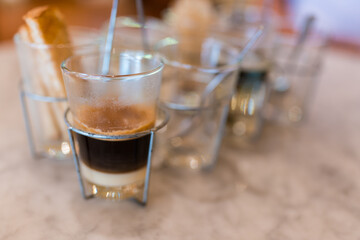 A cup of hot coffee with sweetened condensed milk served in a glass. Thai style hot coffee in vintage glass on table background