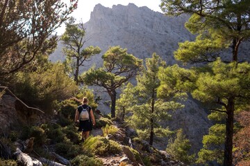 Back view of a backpacker on a hiking trail in the beautiful Halari gorge on the remote Greek island of Ikaria.