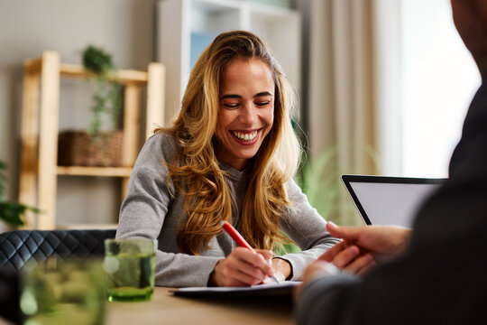 Happy woman signing contract after successful job interview or loan approval